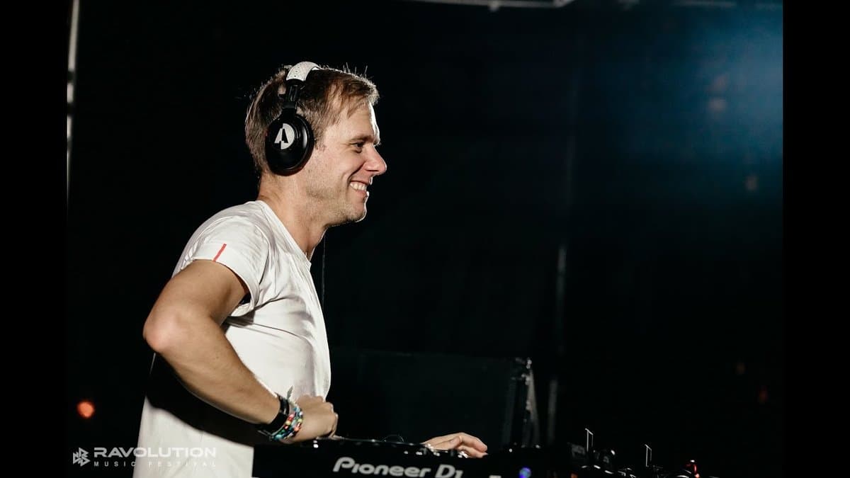 DJ Armin van Buuren đeo tai nghe trình diễn sau bàn DJ